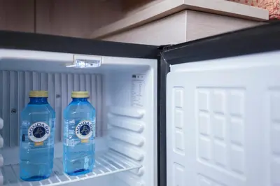two bottles of water sitting inside of an open refrigerator at Hotel Salymar in San Fernando