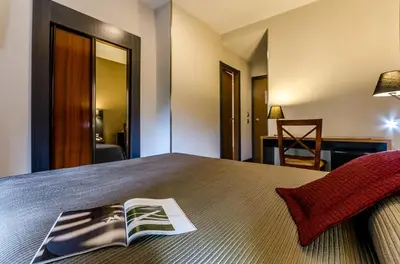 a bedroom with a bed with a book on it at Hotel Regio Cádiz in Cádiz