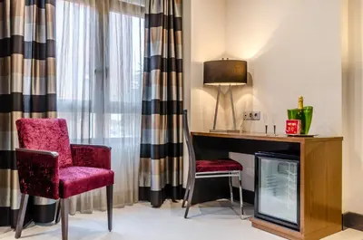 a room with a desk and two chairs and a tv at Hotel Regio Cádiz in Cádiz