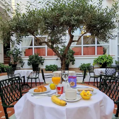 a table with bananas and oranges on a white table cloth at Hotel Los Olivos in Arcos de la Frontera