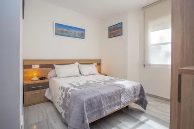 a bedroom with a bed and a window at Wehost-costaluz Apartamento Sanlúcar con parking in Sanlúcar de Barrameda