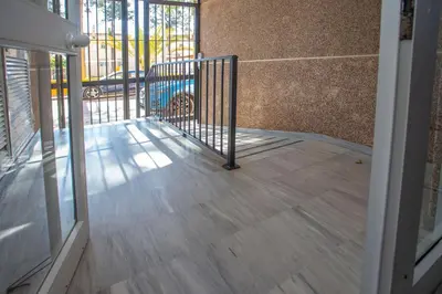 an empty room with a balcony with a gate at Wehost-costaluz Apartamento Sanlúcar con parking in Sanlúcar de Barrameda