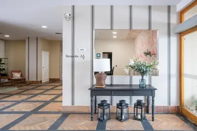 a lobby with a table with a lamp and flowers at Soho Boutique Puerto in El Puerto de Santa María