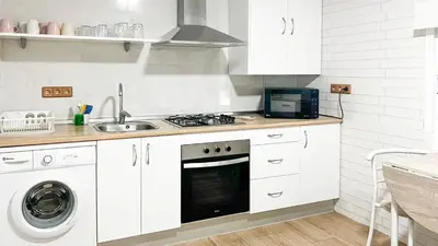 a white kitchen with a stove and a sink at Los Arcángeles Chiclana de la Frontera by Ruralidays in Chiclana de la Frontera
