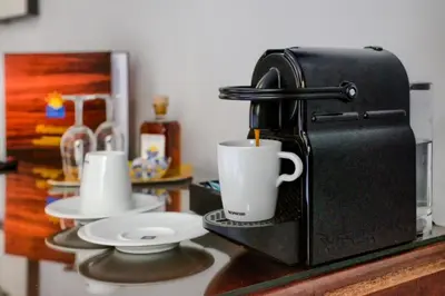 a coffee maker sitting on a counter with two cups at Hotel Playa de Regla in Chipiona