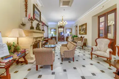 a living room with chairs and a fireplace at Hotel Playa de Regla in Chipiona