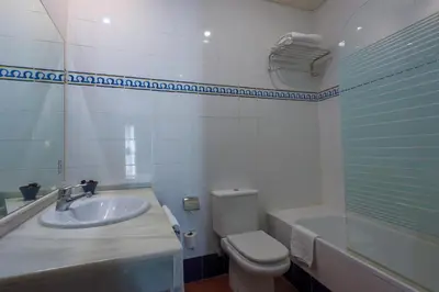 a bathroom with a sink and a toilet and a tub at Casa del Regidor in El Puerto de Santa María