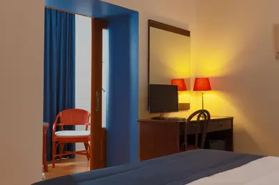 a bedroom with a bed and a desk with a television at Casa del Regidor in El Puerto de Santa María