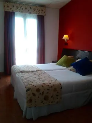 a bedroom with two beds and a window at Casa del Regidor in El Puerto de Santa María