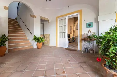 a hallway of a house with stairs and potted plants at Loft Bodega San Blas con porche y parking in Jerez de la Frontera