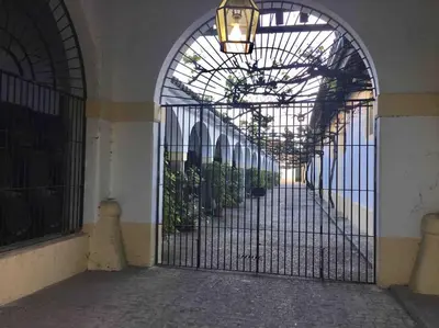 an entrance to a building with an iron gate with plants at Loft Bodega San Blas con porche y parking in Jerez de la Frontera