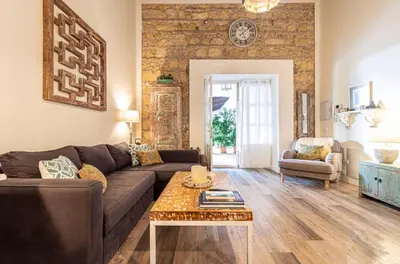 a living room with a couch and a table at Loft Bodega San Blas con porche y parking in Jerez de la Frontera