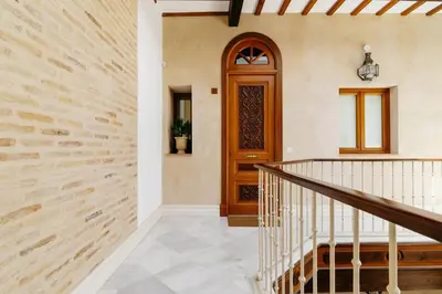 a hallway with a wooden door and stairs at innCádizPalacio Apolo in Cádiz