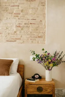 a bedroom with a bed and a table with a vase of flowers at innCádizPalacio Apolo in Cádiz