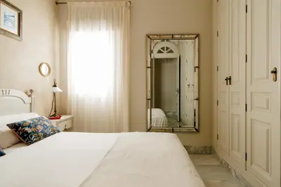 a bedroom with a bed and a mirror at innCádizPalacio Apolo in Cádiz