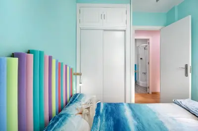 a bedroom with a colorful wall of books at La Gaviota in Rota