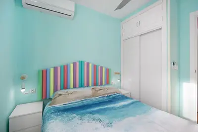 a bedroom with a bed with a colorful headboard at La Gaviota in Rota