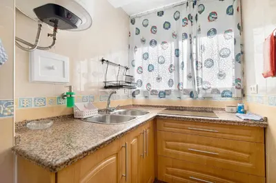 a kitchen with a sink and a shower curtain at La Gaviota in Rota
