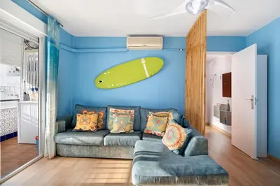 a living room with a couch and a surfboard on the wall at La Gaviota in Rota