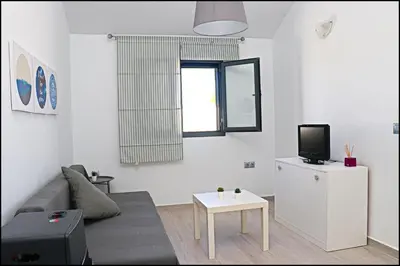 a living room with a couch and a tv at Chalet los Morenos in Conil de la Frontera