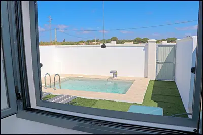 a view of a swimming pool from a window at Chalet los Morenos in Conil de la Frontera