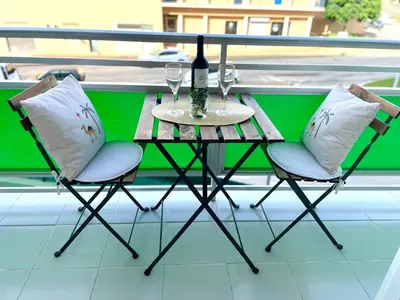 a table with two chairs and a bottle of wine at GATU Villa Sol, junto a la playa , piscina, 2 baños, aire cc, terraza, 