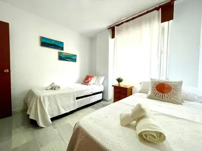 a bedroom with two beds and a window at GATU Villa Sol, junto a la playa , piscina, 2 baños, aire cc, terraza, 