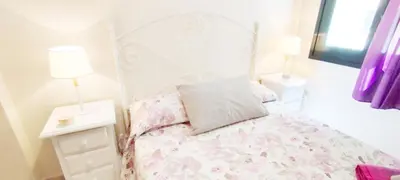 a bedroom with a bed and two lamps and a window at Apartamento Tres Carabelas II, AC, Wifi, Parking in Sanlúcar de Barrameda