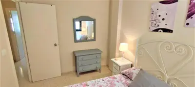 a bedroom with a bed and a dresser and a mirror at Apartamento Tres Carabelas II, AC, Wifi, Parking in Sanlúcar de Barrameda