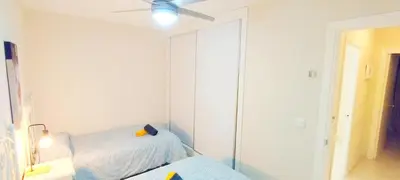a bedroom with two beds and a ceiling fan at Apartamento Tres Carabelas II, AC, Wifi, Parking in Sanlúcar de Barrameda