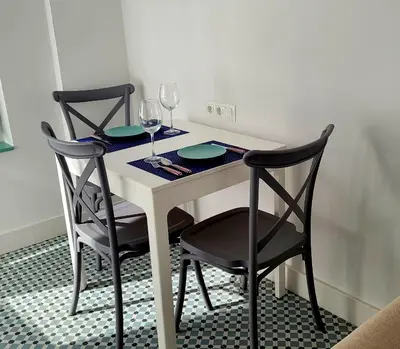 a table with two chairs and two glasses of wine at Casa Tina in Cádiz