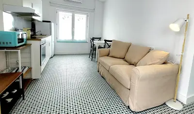 a living room with a couch and a kitchen at Casa Tina in Cádiz