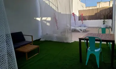 a room with green carpet and a table and chairs at Casa Tina in Cádiz