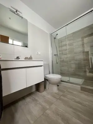 a bathroom with a toilet and a glass shower at Ático centro in El Puerto de Santa María