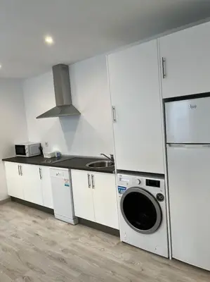 a kitchen with white cabinets and a washing machine at Ático centro in El Puerto de Santa María