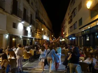 a group of people walking down a street at night at Ático centro in El Puerto de Santa María