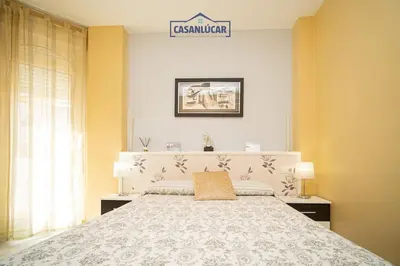 a bedroom with a bed and a sign on the wall at Apartamento la Infanta in Sanlúcar de Barrameda