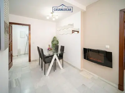 a dining room with a table and a fireplace at Apartamento la Infanta in Sanlúcar de Barrameda