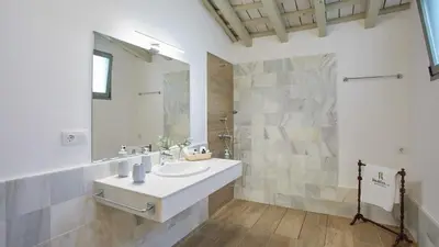 a white bathroom with a sink and a mirror at Casa Rural Viña Romanito Jerez de la Frontera by Ruralidays in Jerez de la Frontera