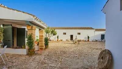a courtyard of a house with a table and chairs at Casa Rural Viña Romanito Jerez de la Frontera by Ruralidays in Jerez de la Frontera