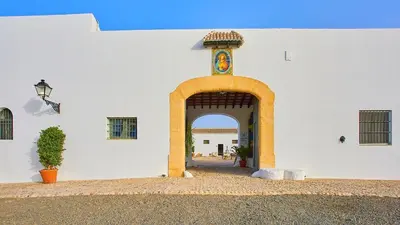 an entrance to a white building with an arch at Casa Rural Viña Romanito Jerez de la Frontera by Ruralidays in Jerez de la Frontera