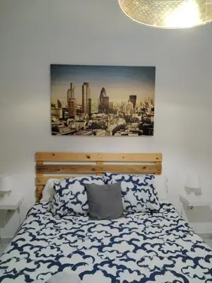 a bedroom with a bed with a picture on the wall at BF BOUTIQUE JEREZ in Jerez de la Frontera