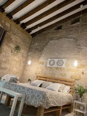a bedroom with a bed in a brick wall at BF BOUTIQUE JEREZ in Jerez de la Frontera