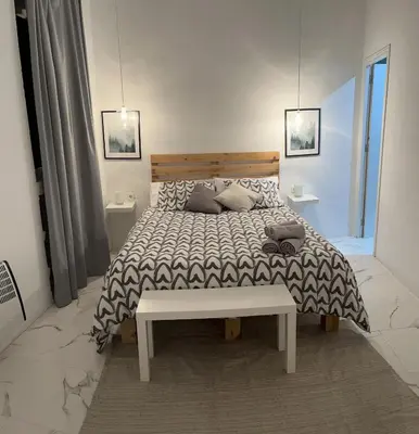 a bedroom with a bed with a bench on it at BF BOUTIQUE JEREZ in Jerez de la Frontera