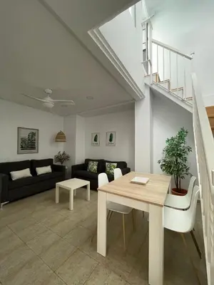a living room with a table and a couch at Dúplex Céntrico perfecto para el disfrute in El Puerto de Santa María