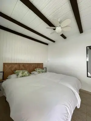 a bedroom with a white bed with a ceiling fan at Dúplex Céntrico perfecto para el disfrute in El Puerto de Santa María