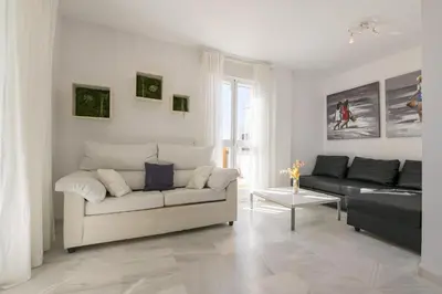 a white living room with a couch and a table at Atico Costa Doñana in Bonanza