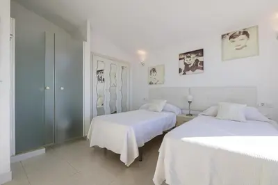 two beds in a room with white walls at Atico Costa Doñana in Bonanza