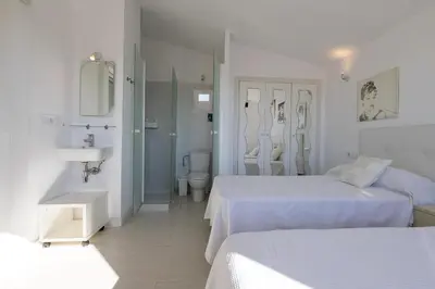 a white room with two beds and a sink at Atico Costa Doñana in Bonanza