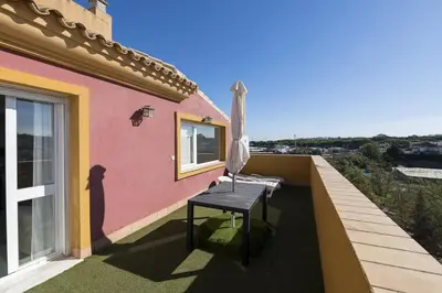 a patio with a table and an umbrella on a house at Atico Costa Doñana in Bonanza